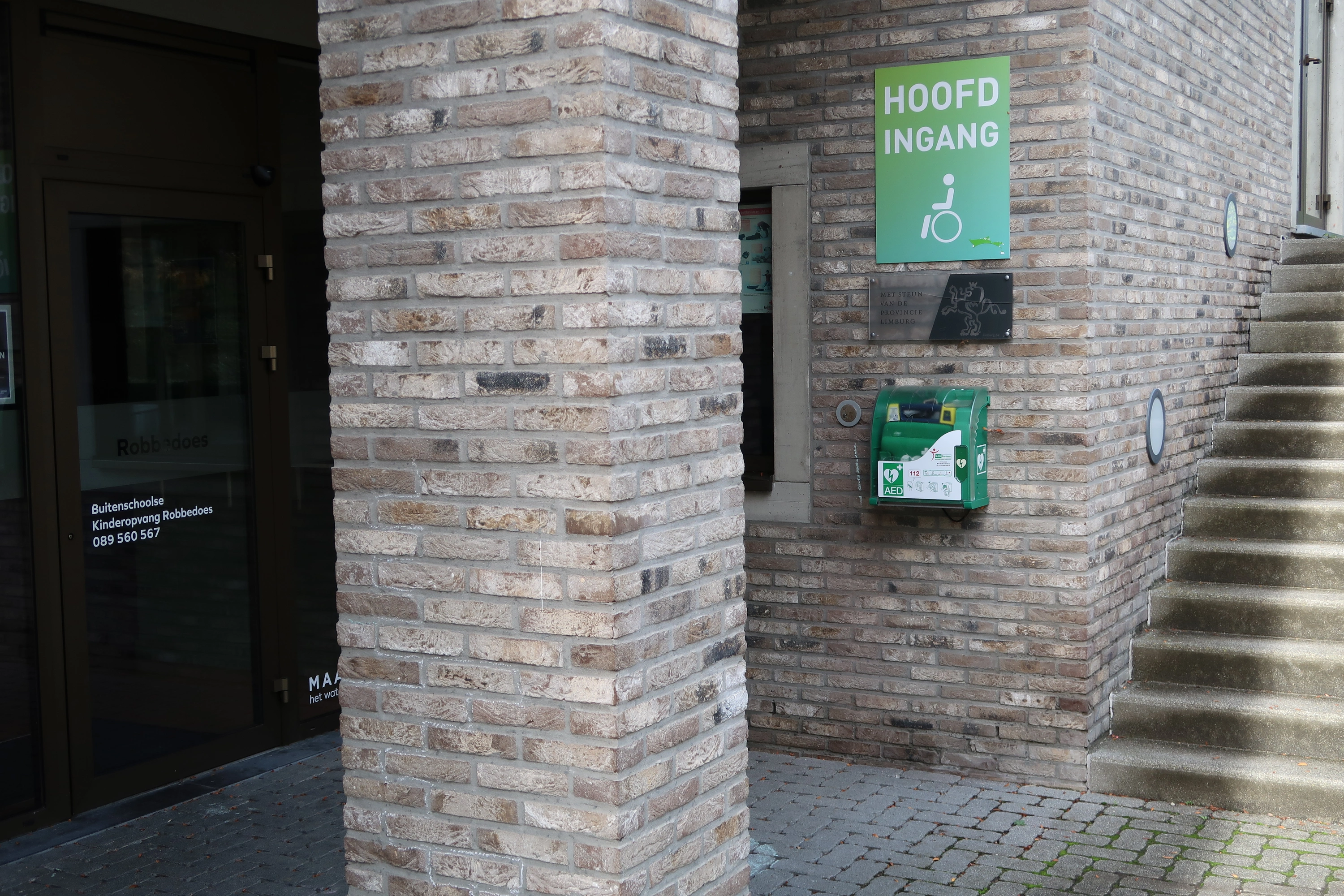 AED Buiten bij de hoofdingang van De Riet bij de buitentrap