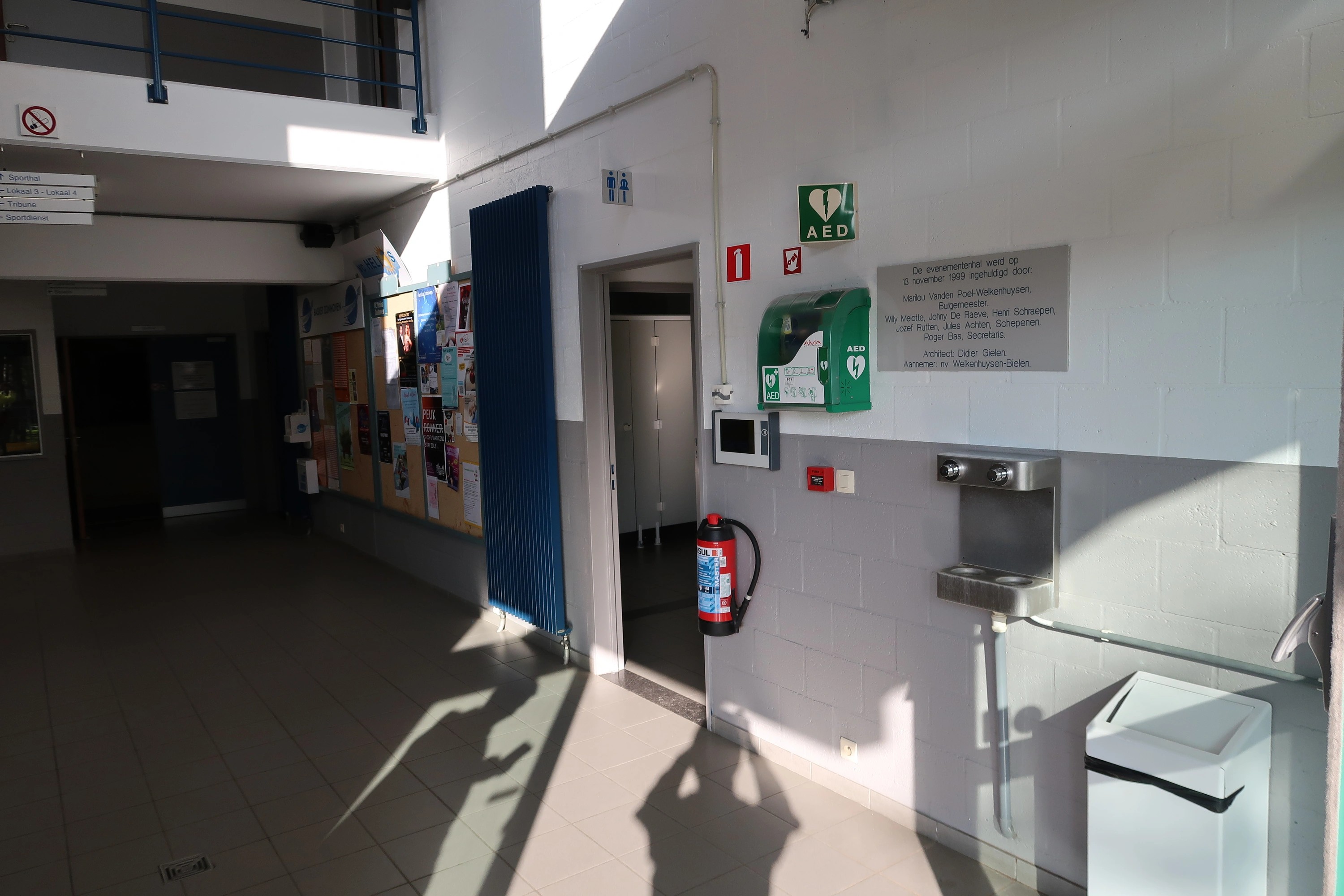 AED binnen in de inkomhal van sporthal bij het loket
