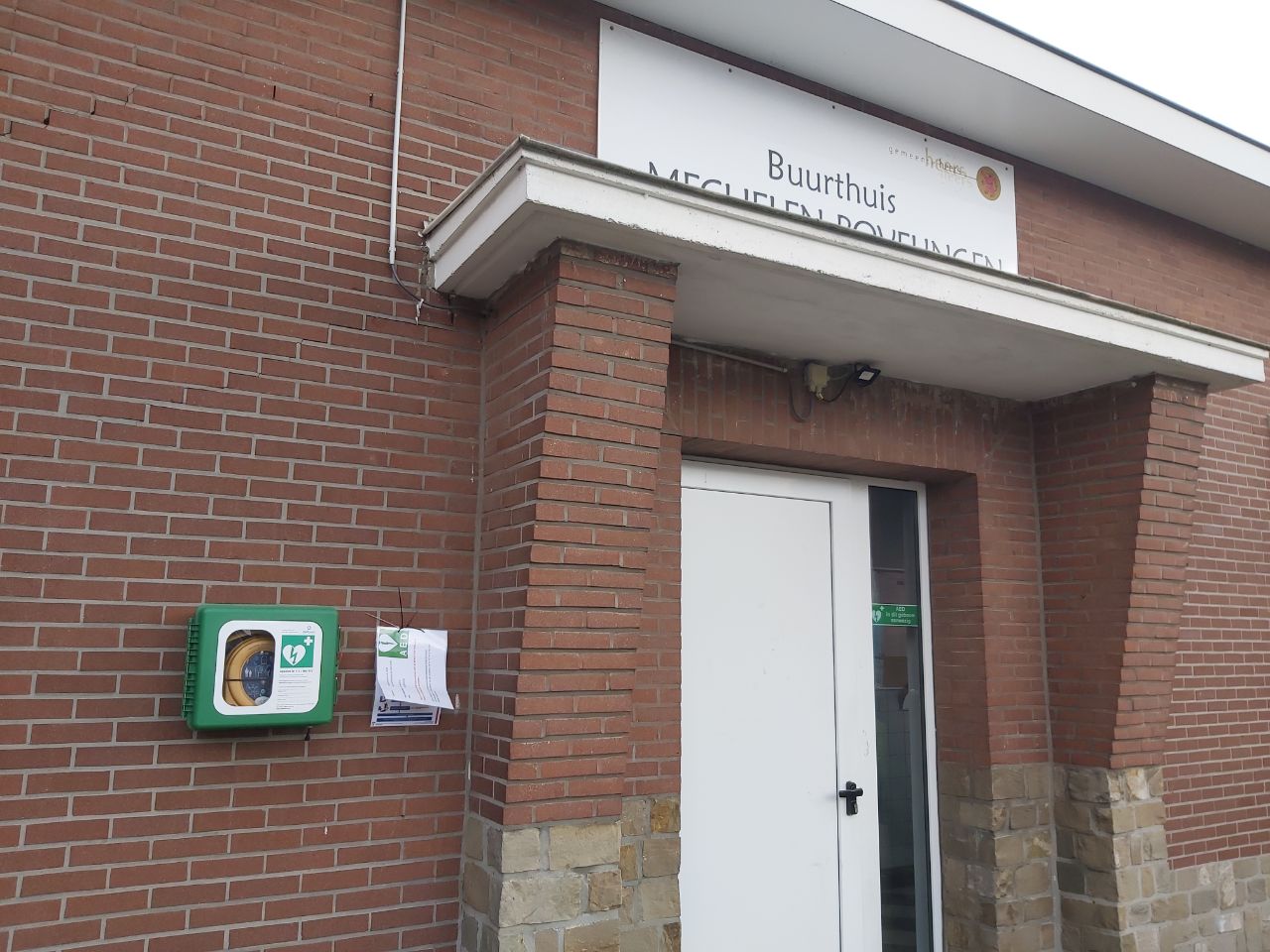 AED Aan de voorgevel van het buurthuis, naast de ingangsdeur