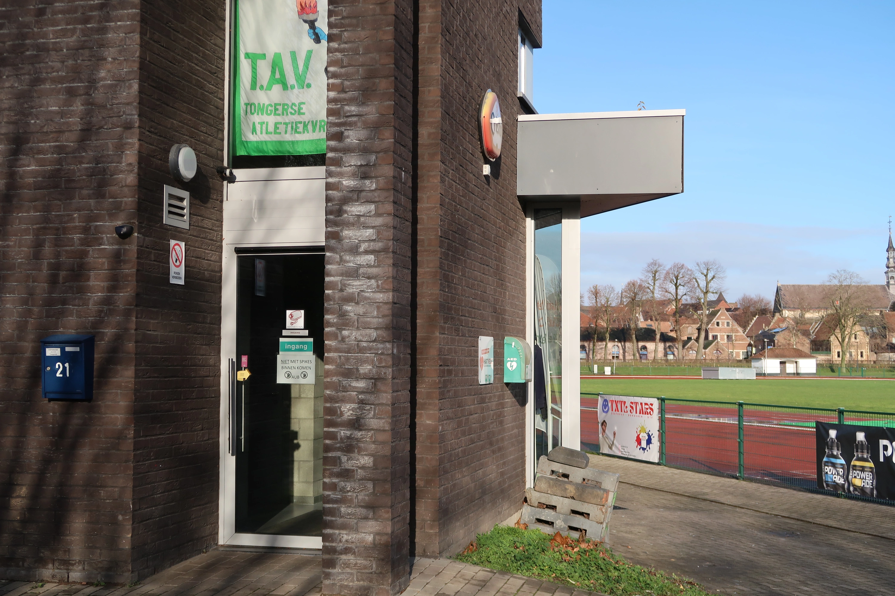 AED Buiten op de hoek van het gebouw van de atletiekclub, rechts van de ingang