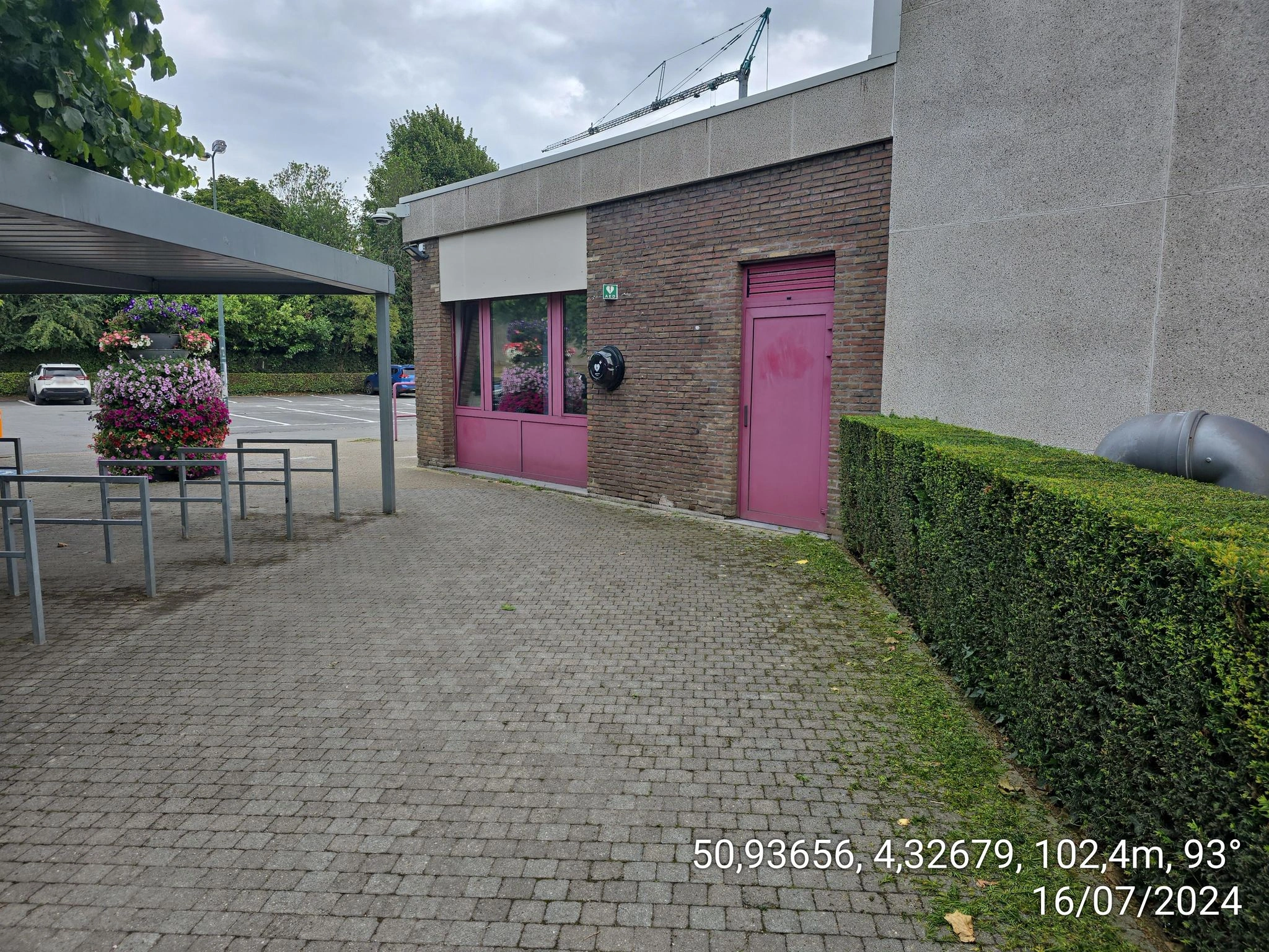 AED Zwembad, buitengevel rechts ter hoogte van de fietsenstalling tegen de muur.