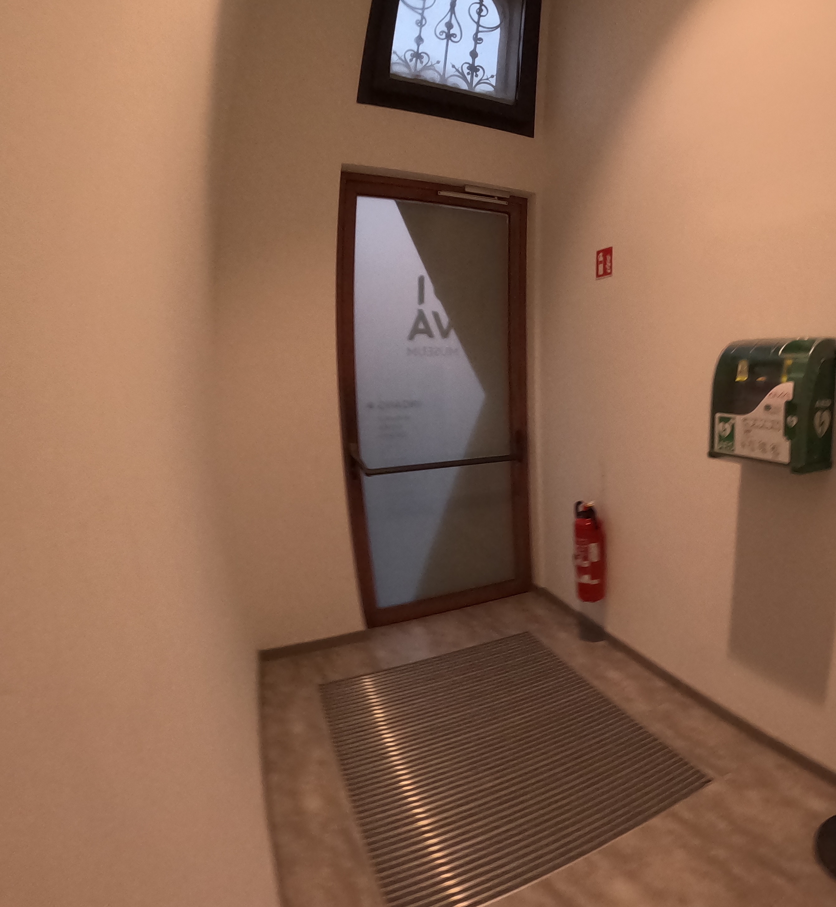 AED Museum DIVA. Links, links van de balie is er een niet gemarkeerde witte deur.    Daarachter is de AED aan de m