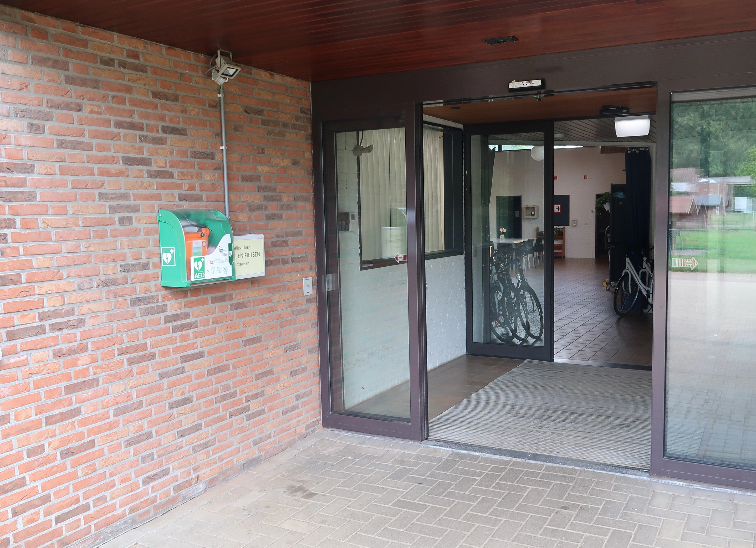 AED Buiten onder het afdak bij de ingang van het therapiecentrum van 't Weyerke