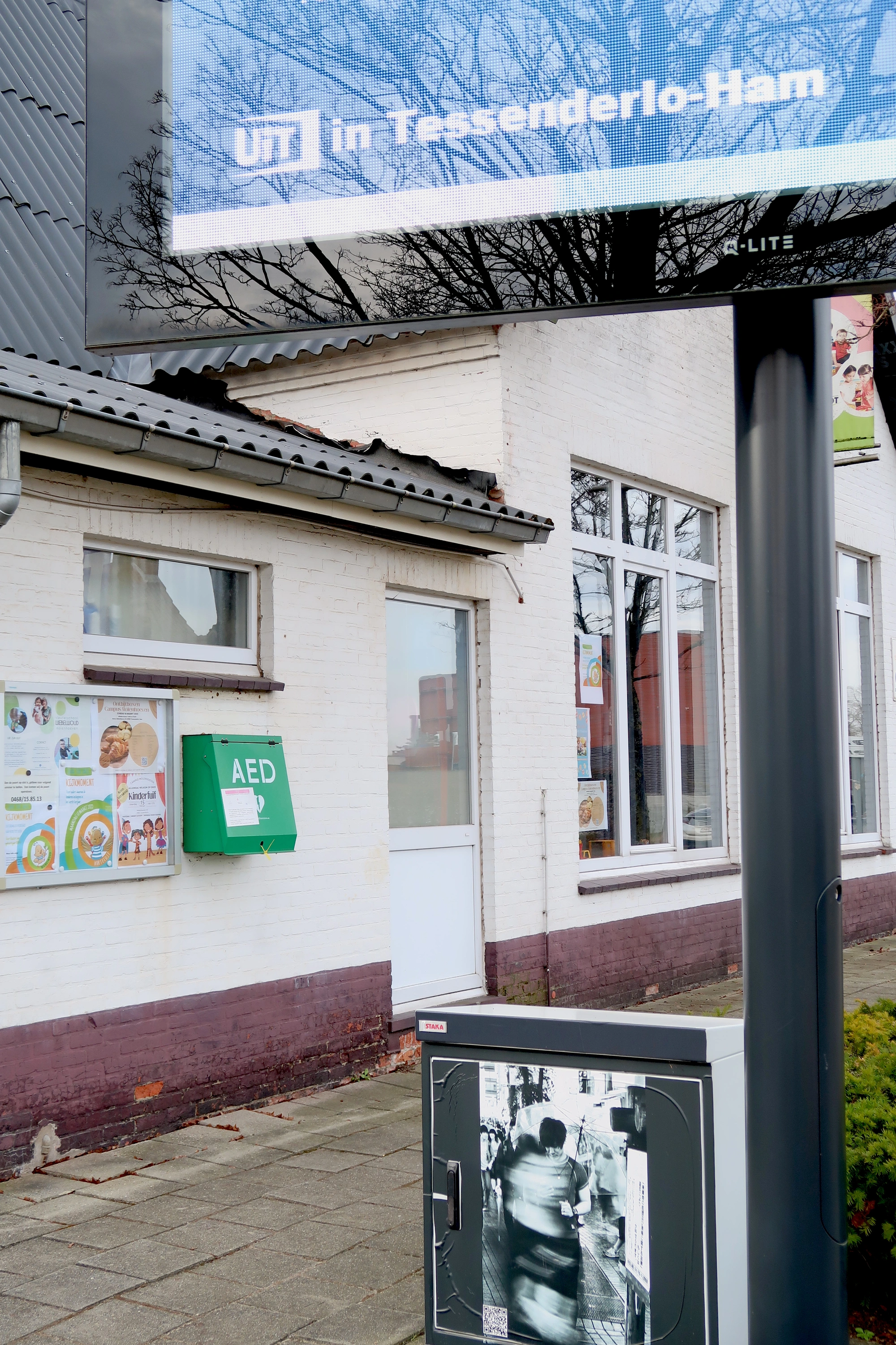 AED Aan de straatkant tegen de school bij het infoscherm