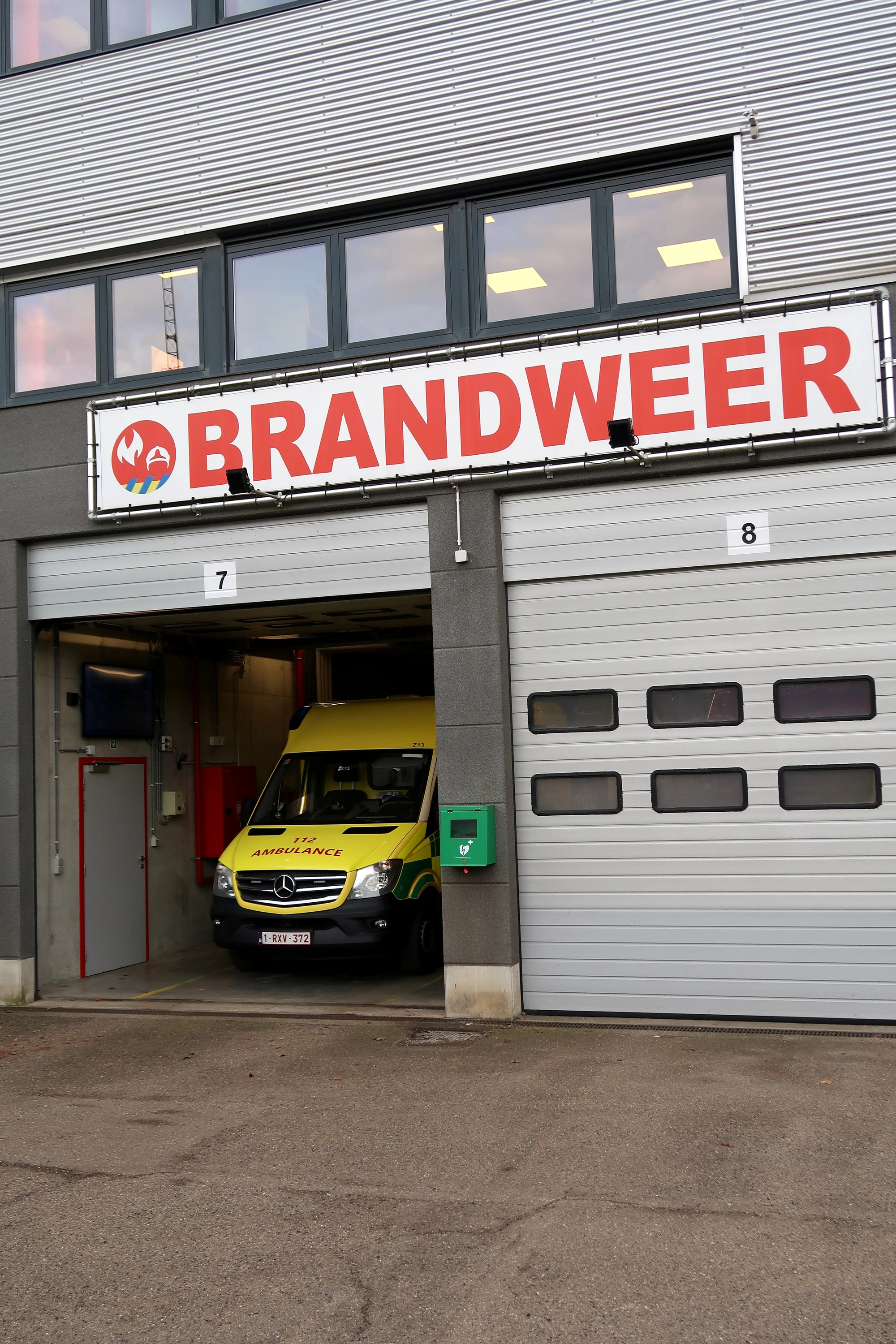 AED Aan de voorgevel van de brandweerkazerne tussen poort 7 en 8