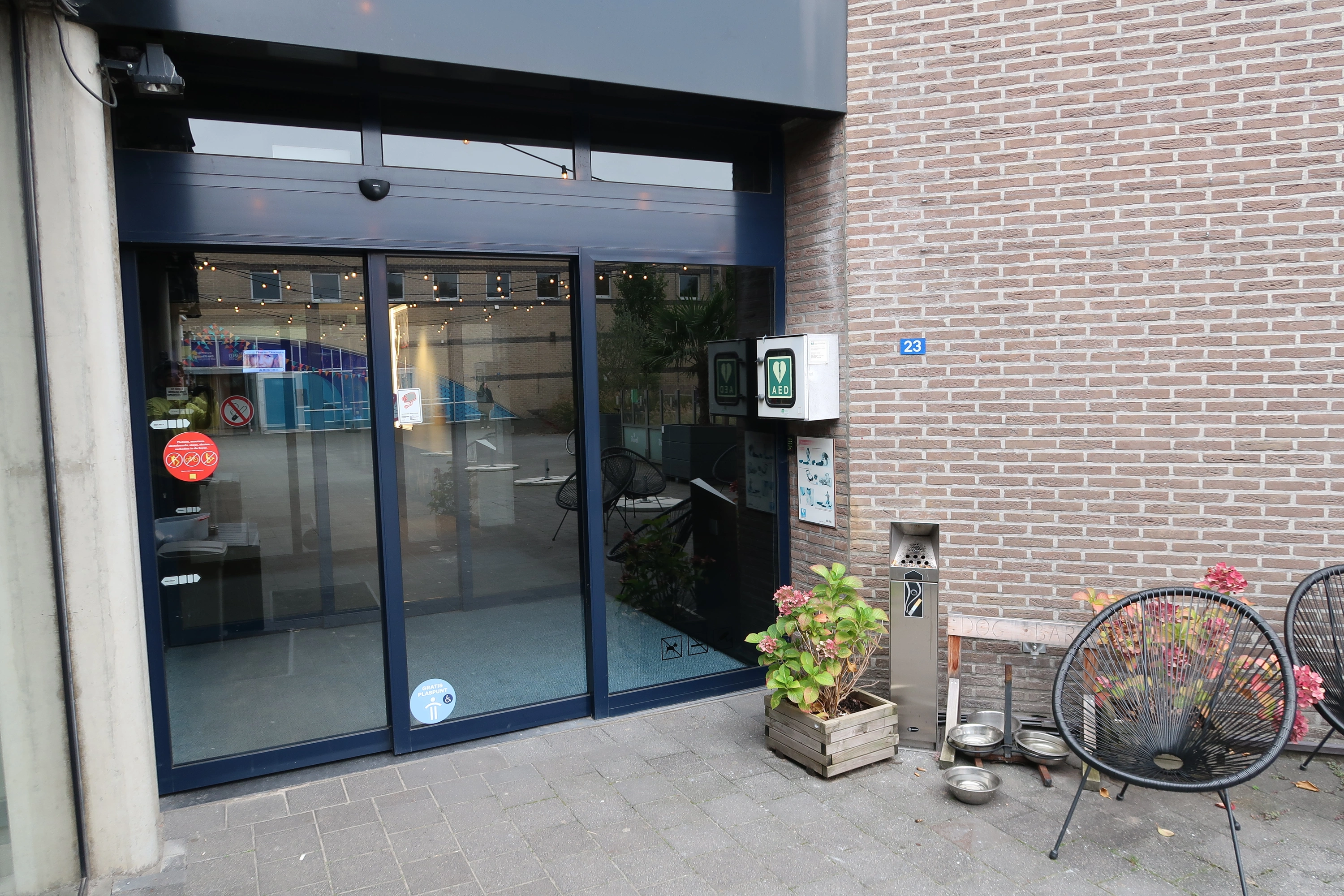 AED Buiten bij de ingang van het Theatercafé in de linkerzijgevel van De Kimpel