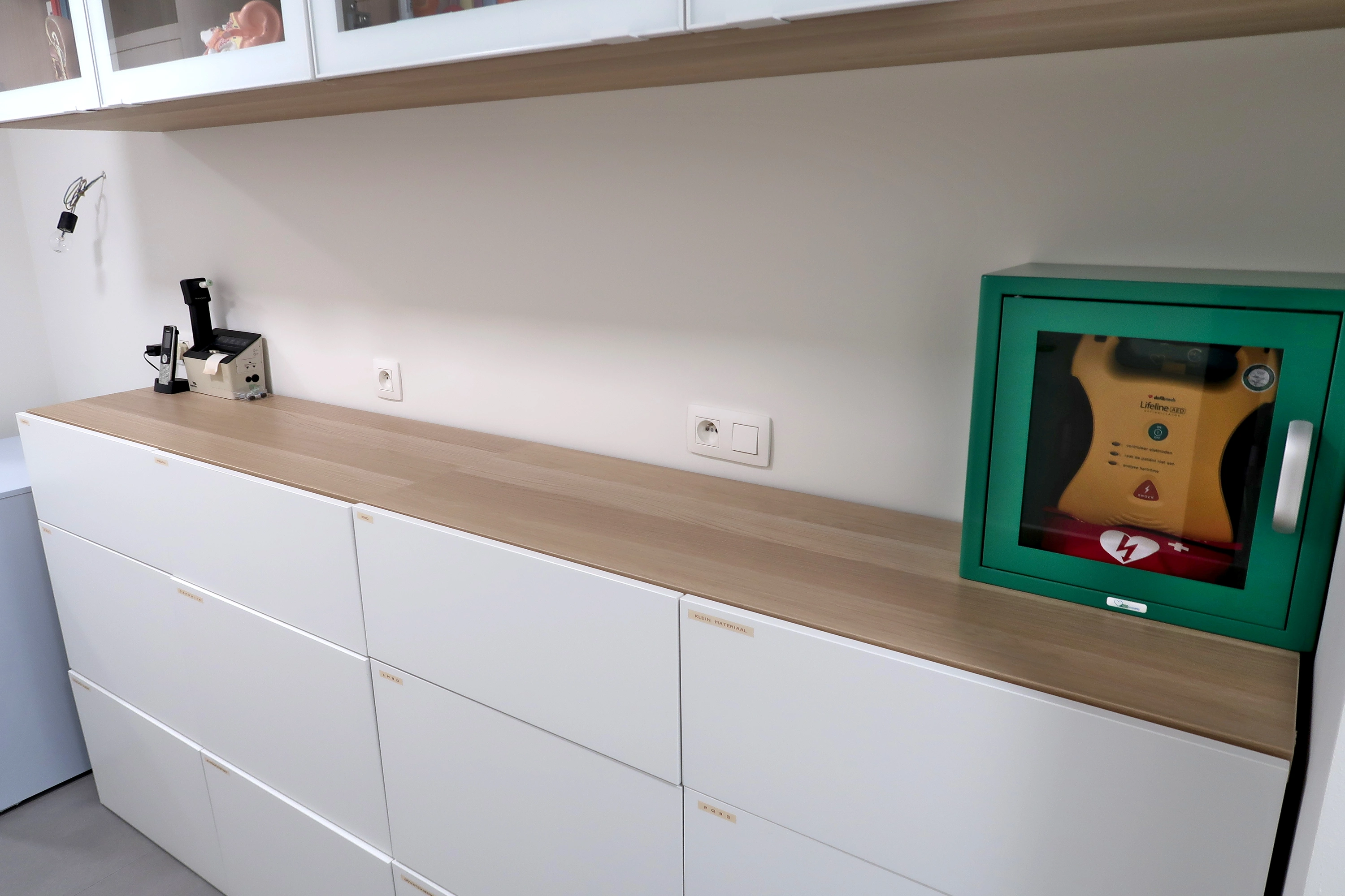 AED In de gang voorbij het onthaal van de huisartsenpraktijk