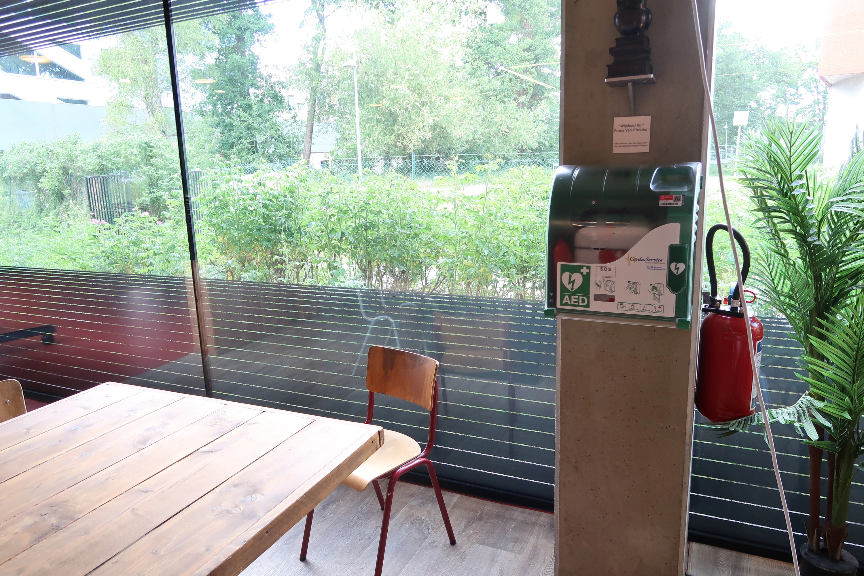 AED In UCLL gebouw S Management, in de benedenruimte tegen te buitenmuur links van de trap